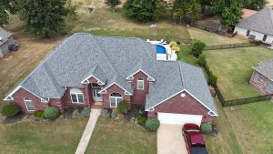 Overhead drone shot of a clean gray shingle roof on a red brick home, highlighting the uniform pattern and new materials.